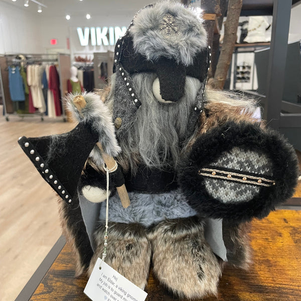 Fur coat with decorative elements displayed indoors, possibly in a store or exhibition setting.