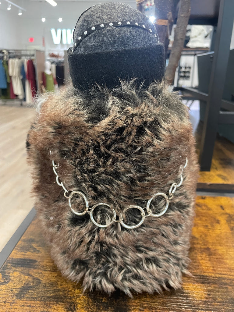 Furry handbag with chain detail on a wooden surface