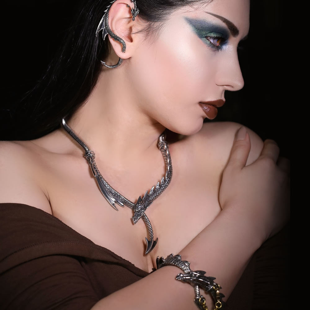 Woman wearing silver dragon-themed jewelry against a dark background